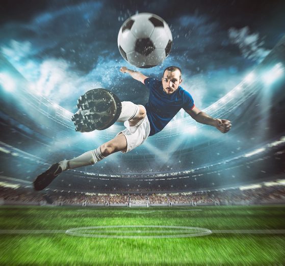 Footballer in action under stadium lights